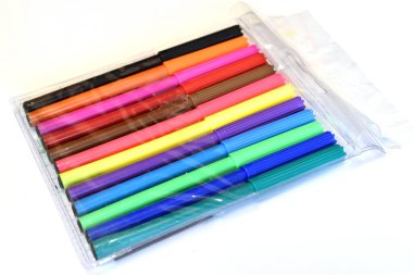 Şeffaf paketlemedeki farklı renklerin işaretleri beyaz arkaplanda yatar.