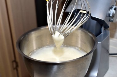 Bir damla kremalı çırpıcı ve kremalı paslanmaz kase..