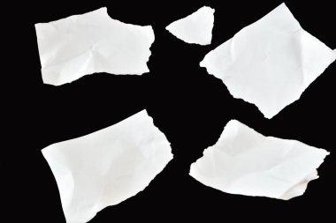 Siyah arka planda, dört temiz beyaz çarşaf kaotik bir şekilde yatar. Buruşmuşlar ve kenarları pürüzlü..