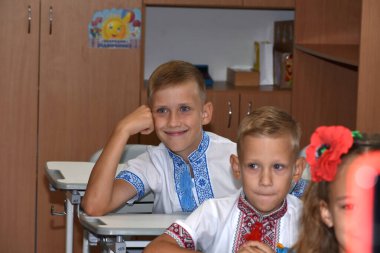 Birinci sınıflar sınıftaki masalarda otururlar, her biri kendi yerinde..