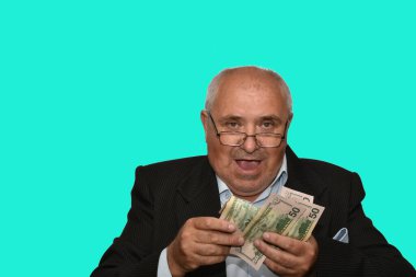 Elinde para tutan, mutlu, gülümseyen, yaşlı bir adamın portresi..