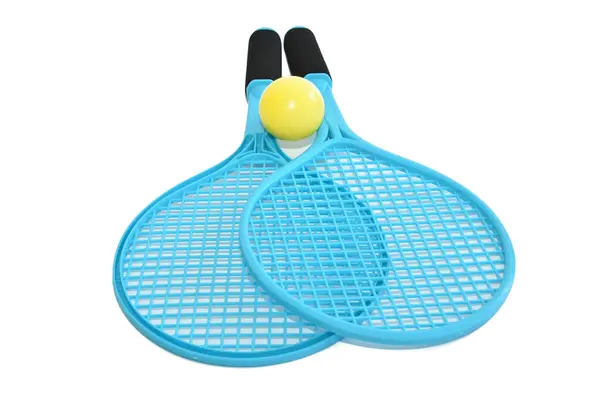 Stock image Two children's blue plastic rackets and a yellow ball.