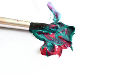 Beyaz arka planda iki boya ve bir sanatçının fırçasının birleşiminden bir leke var..