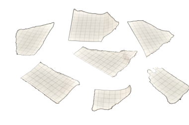 Küçük yırtık beyaz kağıt parçaları siyah arka plana saçılmış..