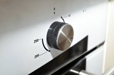 Gaz sobası panelinin yuvarlak sıcaklık kontrol düğmesi..