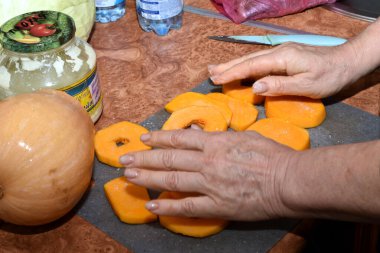 Resim şefin ellerini gösteriyor, taze kesilmiş sebzeler üzerinde bir süre dinleniyor..