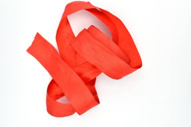 Beyaz arkaplanda kırmızı kumaştan bir kurdele var..