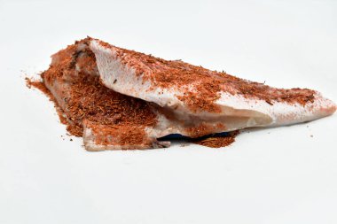 Deniz levreği balığı, aromatik baharatlarla temizlenmiş ve sarılmış, pişirmeye hazır..