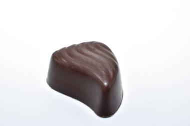 Beyaz arkaplanda su damlası şeklinde çikolata şekeri var..