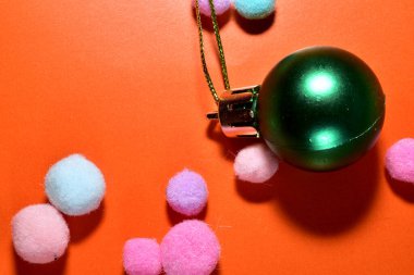 Turuncu arka planda, Noel ağacı süslemesi, yeşil cam bir top. Mutlu Noeller tebrik kartı..