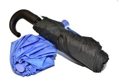 Siyah ve mavi renkli erkek ve kadınların şemsiyeleri beyaz arka planda yatar..