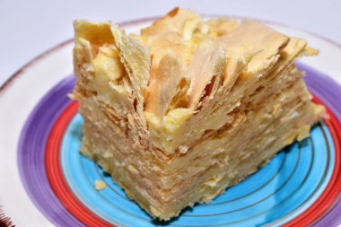 Napolyon adında kremalı büyük bir dilim kek tabakta yatıyor..