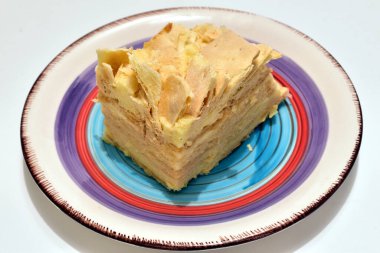 Napolyon adında kremalı katmanlı bir pasta bir tabakta yatıyor..