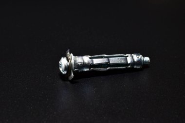 Çapa cıvataları, güve, alçıpanla çalışmak için siyah arka planda yatar..