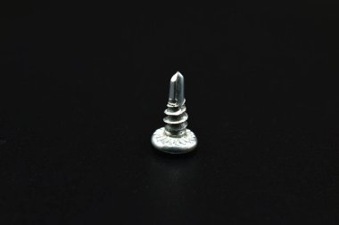 Siyah bir arka planda metal için kısa vuruşlu vida