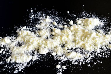 Beyaz kuru süt siyah bir zemine saçılmış..