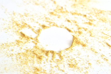 Zemin hardalı beyaz arka plana saçılmış. Tozun ortasında bir çember..