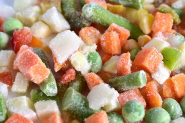Mixture of finely chopped and frozen various vegetables. Close-up.
