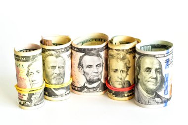 Amerikan dolarları beyaz arka planda farklı değerlere sahip bir tüpe sarılmış..