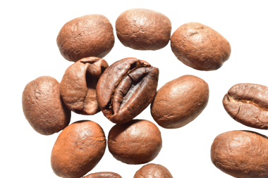 Kavrulmuş kahve çekirdekleri kaotik bir şekilde arka planda yatıyor.