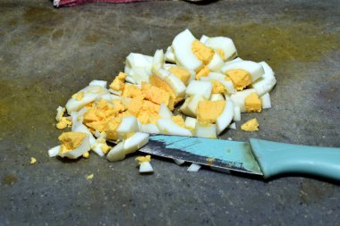 Haşlanmış tavuk yumurtaları ve kesme tahtasının üzerinde bir bıçak var..