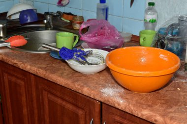 Yemeklerden arta kalan kirli tabaklar lavabonun yanındaki mutfak masasında yatıyor..