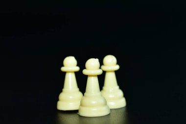 Siyah arka planda beyaz satranç taşları..