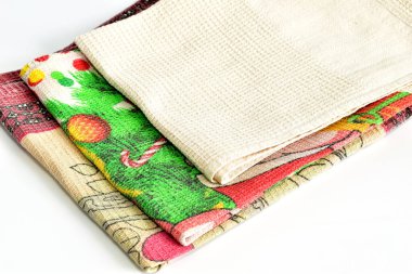 Farklı tonlarda bir yığın el havlusu beyaz arka planda yatıyor..