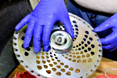 Benzin bidonunun tamiri. Kesme diskinin alt kapağının bir benzin düzenleyicisinin çarkına yerleştirilmesi.