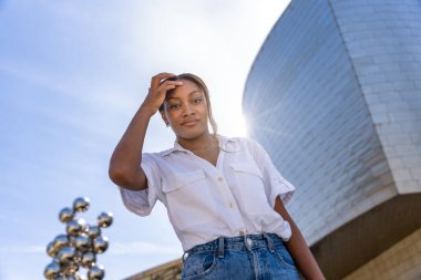 Arka planda Guggenheim Müzesi Bilbao 'suyla saçlarına dokunan genç bir kadının düşük açılı görüntüsü