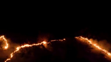 Ormanda ateş ve dumanla gece yangını. Dumanı tüten bir alevin efsanevi hava videosu. Geceleri yanan, parlayan bir ateş. İklim değişikliği, ekoloji. Karanlıkta çizgi yangını..