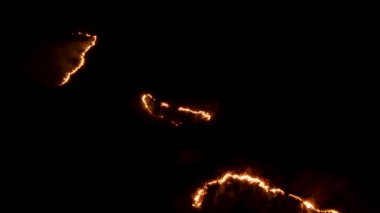 Ormanda ateş ve dumanla gece yangını. Dumanı tüten bir alevin efsanevi hava videosu. Geceleri yanan, parlayan bir ateş. İklim değişikliği, ekoloji. Karanlıkta çizgi yangını..