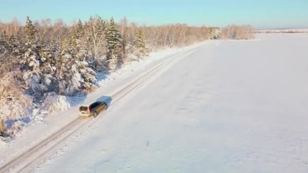 Auto Rijdt Een Besneeuwde Winterweg Vlieg Met Een Drone Door — Stockvideo