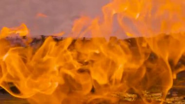Ateş ve alevlerle dolu yavaş çekim videosu. Ateş ve dumanla yanan odun, yakın plan ateşler ve kıvılcımlar. Brezilya 'da cehennem gibi bir parıltı.