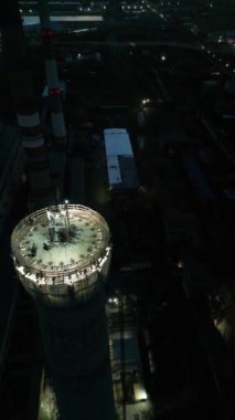 Günbatımında aydınlık bir inşaat alanı. Gece tehlikeli bir iş. İşçiler fabrika için uzun bir baca inşa ediyorlar. İnşaat süreci. Müteahhitlerin yenilenmesi baca yığınıdır. 