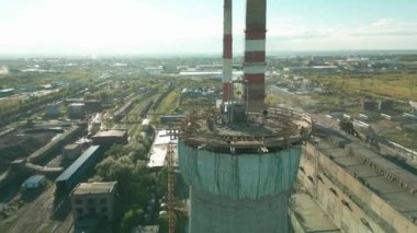 Yüksek bacalı bir elektrik santralinin inşaat sahası. Yüksek seviyede tehlikeli bir iş. Tadilat duman yığınıdır. Müteahhit, yüksek bir binanın bacasını onarıyor..