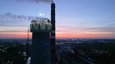 Bir çatı ekibinin işyeri. Nükleer enerji santralinin inşaat süreci. Nükleer enerji. Gün batımında aydınlık bir inşaat sahası. Geceleri tehlikeli işler. Miğferli işçiler bir baca yapıyor.