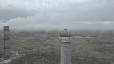 Elektrik santralinde yeni bir baca inşaatı. Yükseklerde inşaat alanı. Miğferli adamlar. Nükleer teknolojiler, nükleer santral inşaatı. Koruyucu kask takan erkek mühendisler..