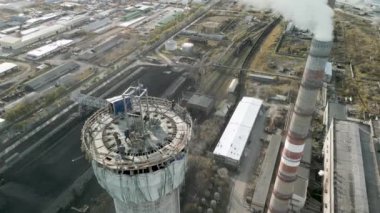 Elektrik santralinde yeni bir baca inşaatı. Yükseklerde inşaat alanı. Miğferli adamlar. Nükleer teknolojiler, nükleer santral inşaatı. Koruyucu kask takan erkek mühendisler..