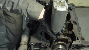 Motor tamiri. Tamirci tamirhanede araba motoru üzerinde çalışıyor. Otomobil servisini tamir et. Araba servisinde ingiliz anahtarı olan tamircinin elleri. Yakın çekim. Motorlu profesyonel tamirci.