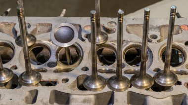 Araba motor valfleri kapanıyor. Arabanın motorunun bir kısmı. Silindir başlığının modern benzin motor tamiri ayrıntıları. Değiştirilmiş bir mühendisin valfinin kurulumu.
