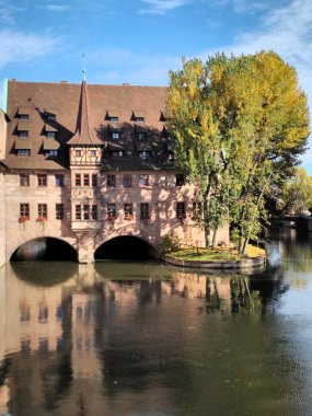 Nuremberg, Germany 10.17.2019 View of Heilig-Geist-Spital from Museumsbrcke in Nuremberg, Germany clipart