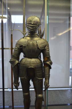 Nuremberg, Almanya 10.19.2019: Titizlikle cilalanmış çelikten yapılmış etkileyici bir ortaçağ zırhı, dik duruyor ve müze vitrininde sergileniyor.