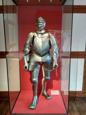 Nuremberg, Almanya 10.17.2019: Titizlikle cilalanmış çelikten yapılmış etkileyici bir ortaçağ zırhı, dik duruyor ve müze vitrininde sergileniyor.