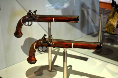 Nuremberg, Almanya 10.17.2019: Bir müze vitrininde sergilenen süslü metal işlemeli ve ahşap stoklu antik çakmaklı tabancalar
