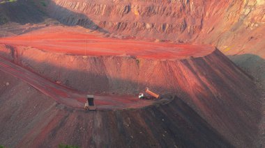 Bulldozers and trucks in quarry with red ground. Mining iron ore in Kriviy Rih, Ukraine. Industrial landscape