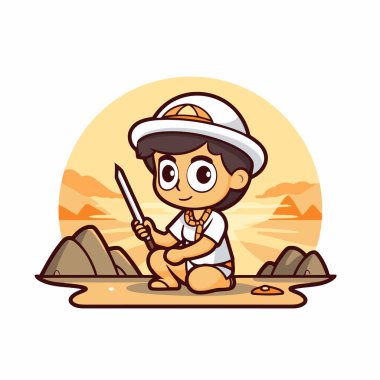 Safari kostümü içinde kumların üzerinde oturan ve elinde mızrak tutan sevimli bir çocuk.