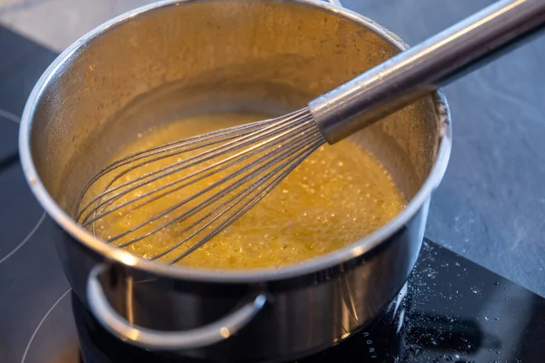 Tereyağını paslanmaz çelikten bir tencerede eritmek siyah soba, yemek pişirme konsepti, seçilmiş odak