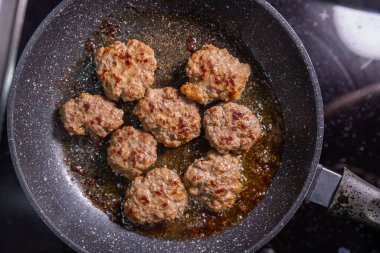 Kızartma tavasında mükemmel kurutulmuş hamburger köfteleri. Kahverengi ve servis etmeye hazır. Lezzetli yağın içinde oturuyor..