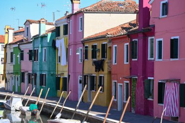 Güneşli bir günde, Burano adasının boş caddelerinde kanalın kıyısına renkli, rahat evler inşa edilmiş ve şehir seti yakınlarında mümkün olan tek ulaşım aracı teknelerdir. ceuropeanoncept: Turizm, geziler, coğrafya, mimari.